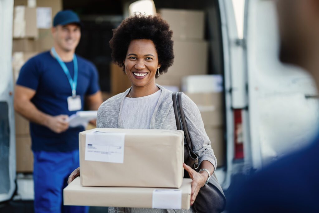 Smiling woman receiving a package from a delivery person